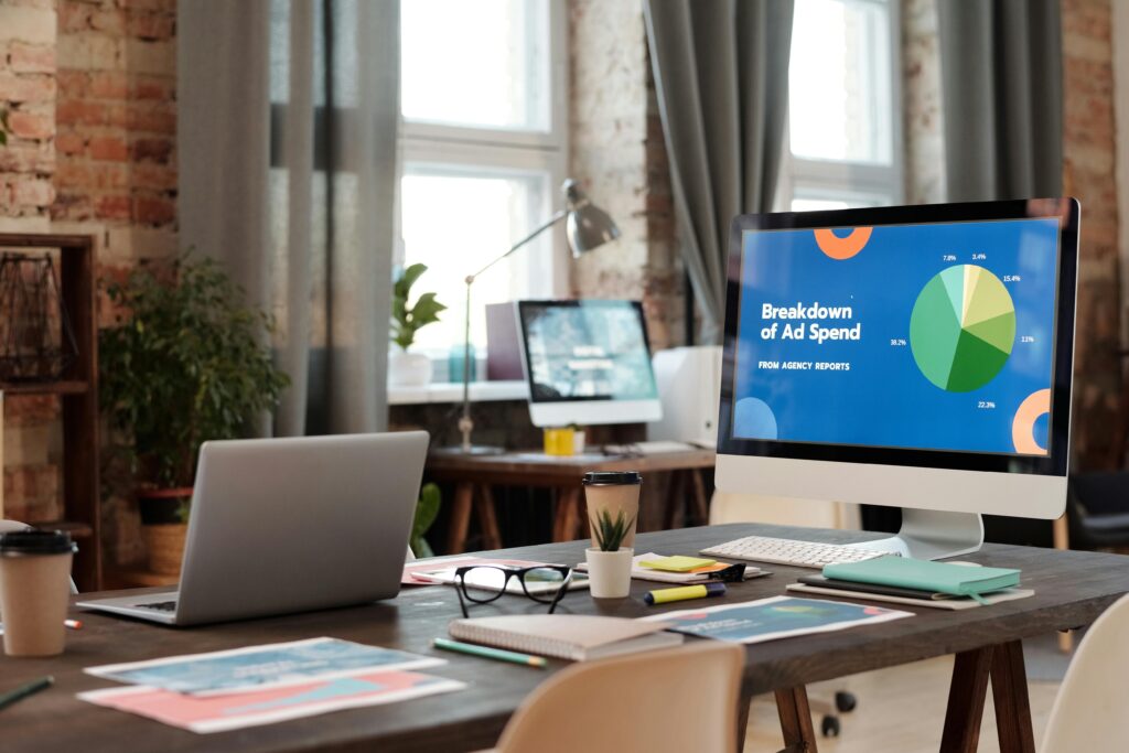 A modern office workspace featuring computers, charts, and office supplies for a productive environment.